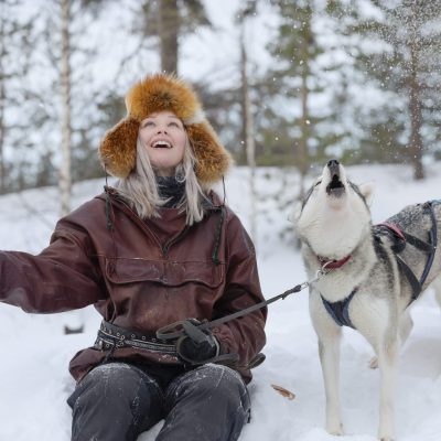 nainen ja husky nauttivat Lapin lumisateesta Sallassa
